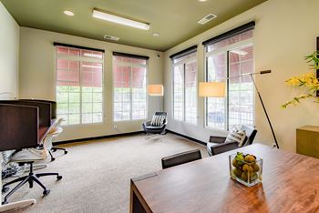 an empty office with a desk and chairs and windows at Riverset Apartments, Memphis, 38103